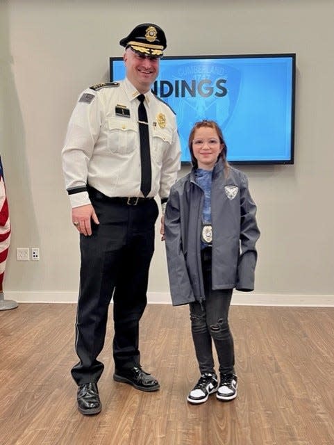 Wearing some of her new gear, 10-year-old Scarlett Doumato poses for a photograph with Cumberland Police Chief Matthew Benson after Benson's press conference announcing the results of their Santa Claus investigation.