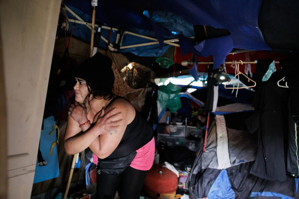 A woman looks around her tent.