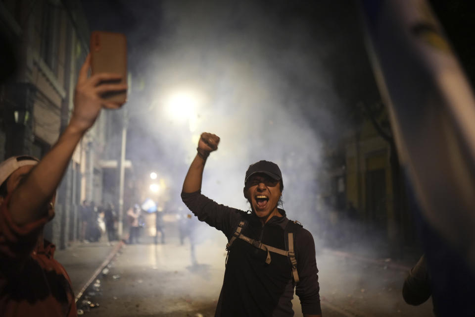 A supporter of Guatemalan President-elect Bernardo Arévalo celebrates that lawmakers voted for a Seed Movement member to be their new Congress president, Samuel Perez, as part of the process before Arévalo's swearing-in ceremony, outside the National Palace in Guatemala City, Sunday, Jan. 14, 2024. (AP Photo/Santiago Billy)