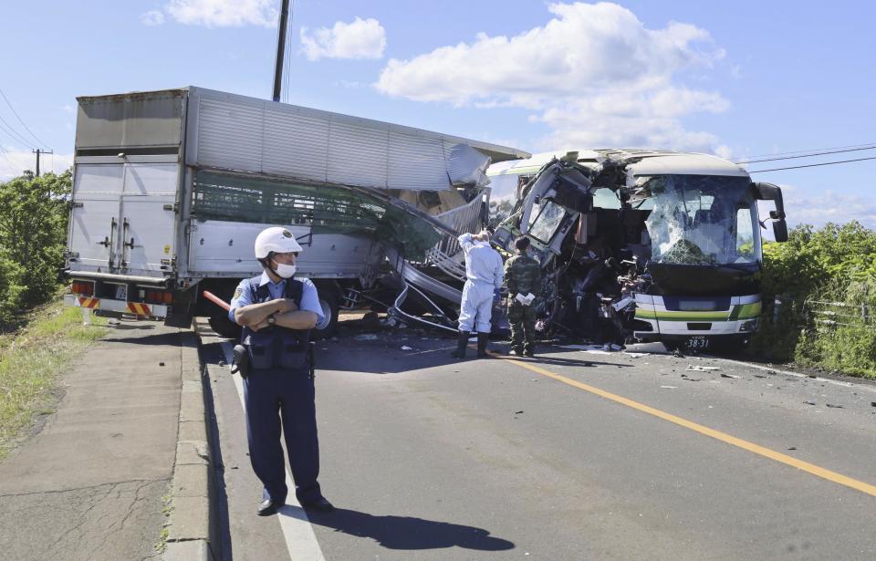 A police stands at the scene of a crash between a bus and a truck in Yakumo, Hokkaido prefecture, northern Japan on June 18, 2023. Several people were killed and 12 others taken to the hospital after a truck collided with a bus in Hokkaido in northern Japan, according to local media reports.(Kyodo News via AP)