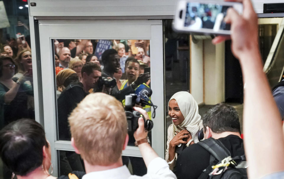 U.S. Rep. Ilhan Omar reacts as she's greeted by supporters cheering "Welcome Home Ilhan!" as she arrived home at Minneapolis–Saint Paul International Airport, Thursday, July 18, 2019, in Minnesota. President Donald Trump is chiding campaign supporters who'd chanted "send her back" about Somali-born Omar, whose loyalty he's challenged. (Glen Stubbe/Star Tribune via AP)