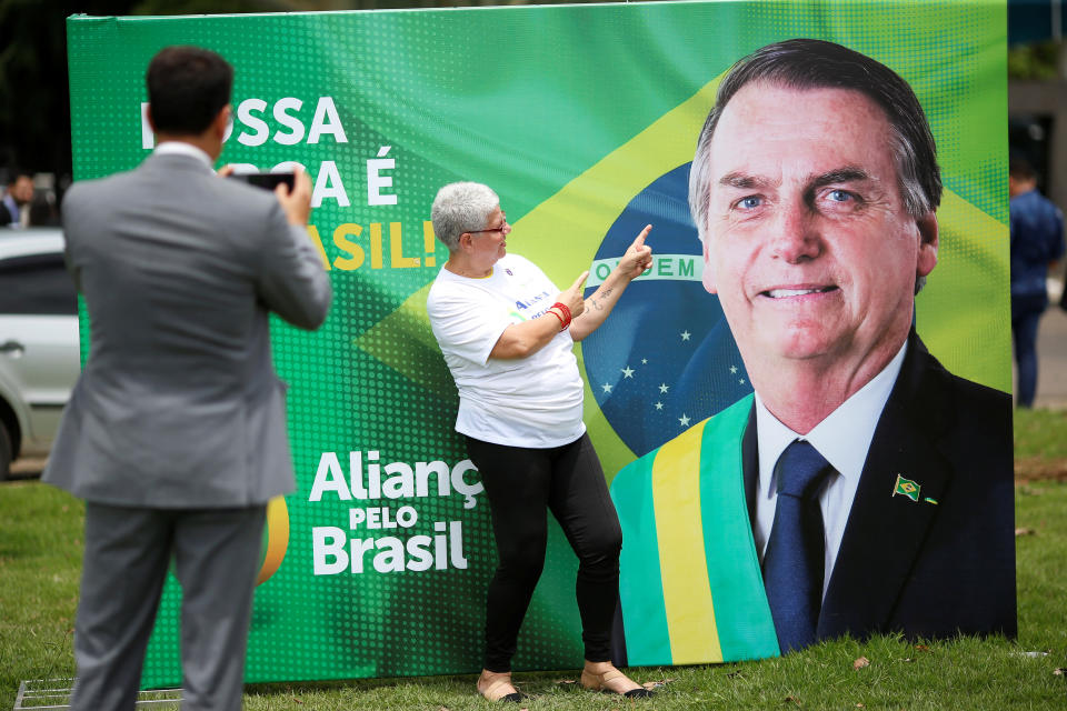 Apoiadora faz foto diante da imagem de Bolsonaro no lançamento de seu novo partido. Foto: Ueslei Marcelino/Reuters