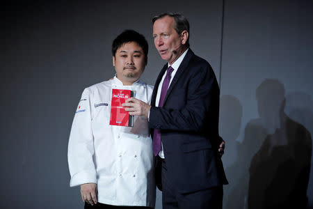 Japanese chef Yoshiaki Ito poses with the Michelin Guide 2017 after been awarded with one Michelin star for the restaurant L'Archeste, in Paris, France, February 9, 2017. REUTERS/Benoit Tessier