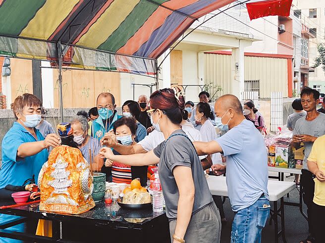 桃園市大園區海口里22日下午在海口埤塘石敢當旁辦理端午傳統祭江儀式，許多里民和信眾到場參與，祈求里內平安與搬遷順遂。（蔡明亘攝）