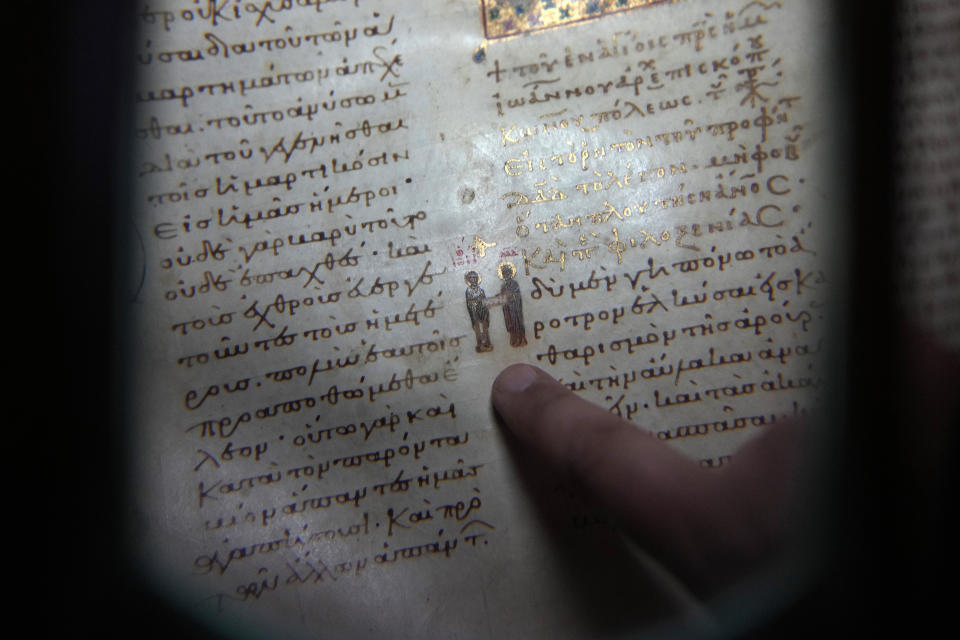 Father Theofilos, a Pantokrator monk, shows a manuscript at the library of Pantokrator Monastery in the Mount Athos, northern Greece, on Thursday, Oct. 13, 2022. Deep inside a medieval fortified monastery in the Mount Athos monastic community, researchers are for the first time tapping a virtually unknown treasure: thousands of Ottoman-era manuscripts that include the oldest of their kind in the world. (AP Photo/Thanassis Stavrakis)