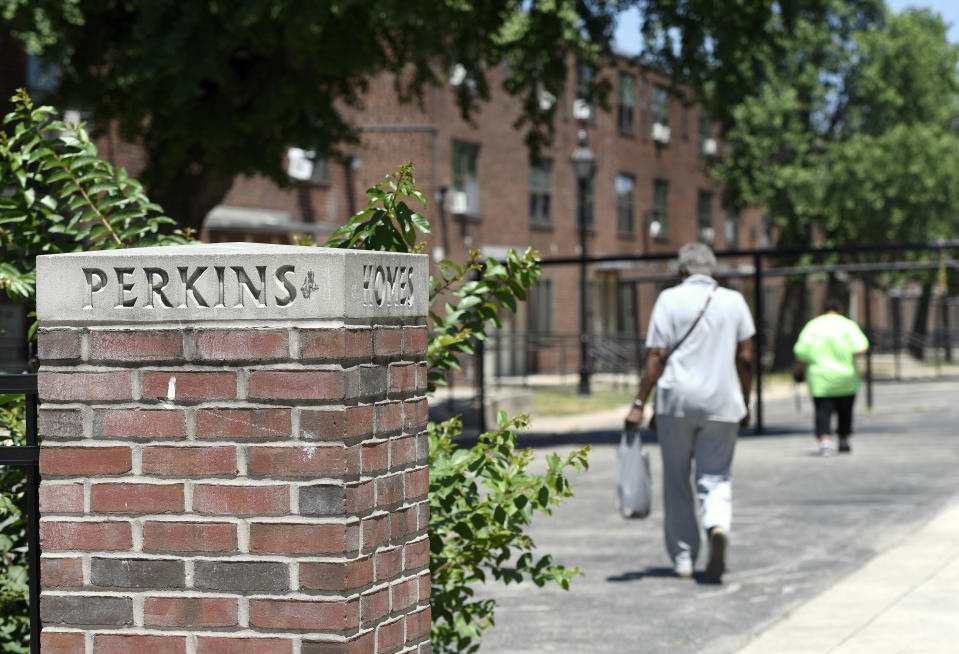Residents walk through a courtyard at the Perkins Homes public housing development in Baltimore on Thursday, July 19, 2018. Ben Carson’s story of growing up in a single-parent household and climbing out of poverty to become a world-renowned surgeon was once ubiquitous in Baltimore, where Carson made his name. But his role in the Trump administration has added a complicated epilogue, leaving many who admired him feeling betrayed, unable to separate him from the politics of a president widely rejected by African Americans here. Carson has come back to Baltimore in an official capacity only three times since becoming HUD secretary. Last month the department gave $144 million in revitalization grants to five cities, including Baltimore. But for the announcement Carson sent a representative to the Perkins Homes housing complex 40 miles from HUD headquarters, opting instead to go to Flint, Mich. (AP Photo/Steve Ruark)
