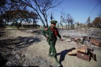 FILE PHOTO: A soldier walks amid the rubble of a neighbourhood in Pauktaw township that was burned in recent violence October 27, 2012. REUTERS/Soe Zeya Tun/File Photo