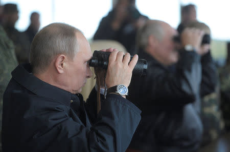 FILE PHOTO: Russia's President Vladimir Putin and his Belarusian counterpart Alexander Lukashenko (R) watch the closing stage of the joint war games Zapad-2013 (West-2013) at the Gozhsky firing range in Grodno, Russia September 26, 2013. REUTERS/Alexei Druzhinin/RIA Novosti/Kremlin/File Photo