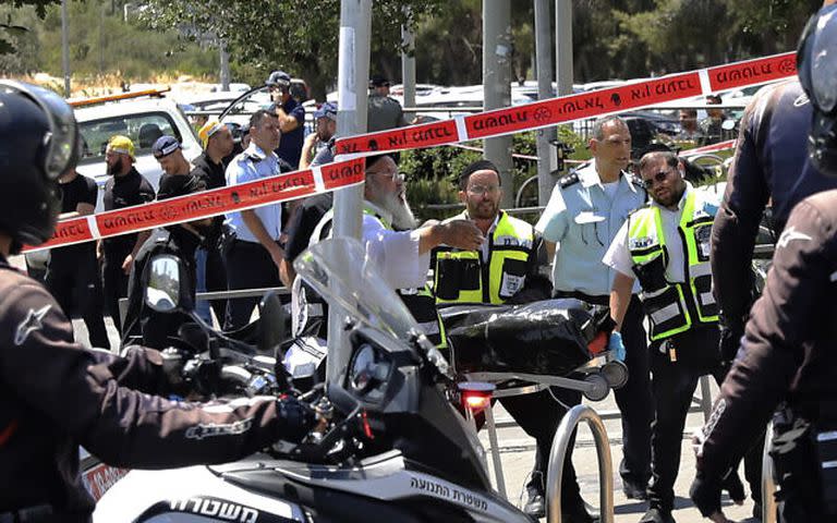 Los rescatistas israelíes retiran un cuerpo de la escena de un ataque en Jerusalén, el lunes 24 de mayo de 2021. Un soldado israelí y un civil fueron apuñalados el lunes cerca de una estación de tren ligero en el este de Jerusalén