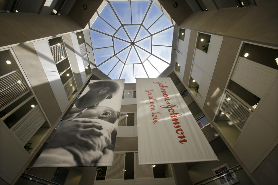 FILE - In this July 30, 2013, file photo, large banners hang in an atrium at the headquarters of Johnson & Johnson in New Brunswick, N.J. Johnson & Johnson is beginning a huge final-stage study Wednesday, Sept. 23, 2020, to try to prove if a single-dose COVID-19 vaccine can protect against the virus. (AP Photo/Mel Evans, File)