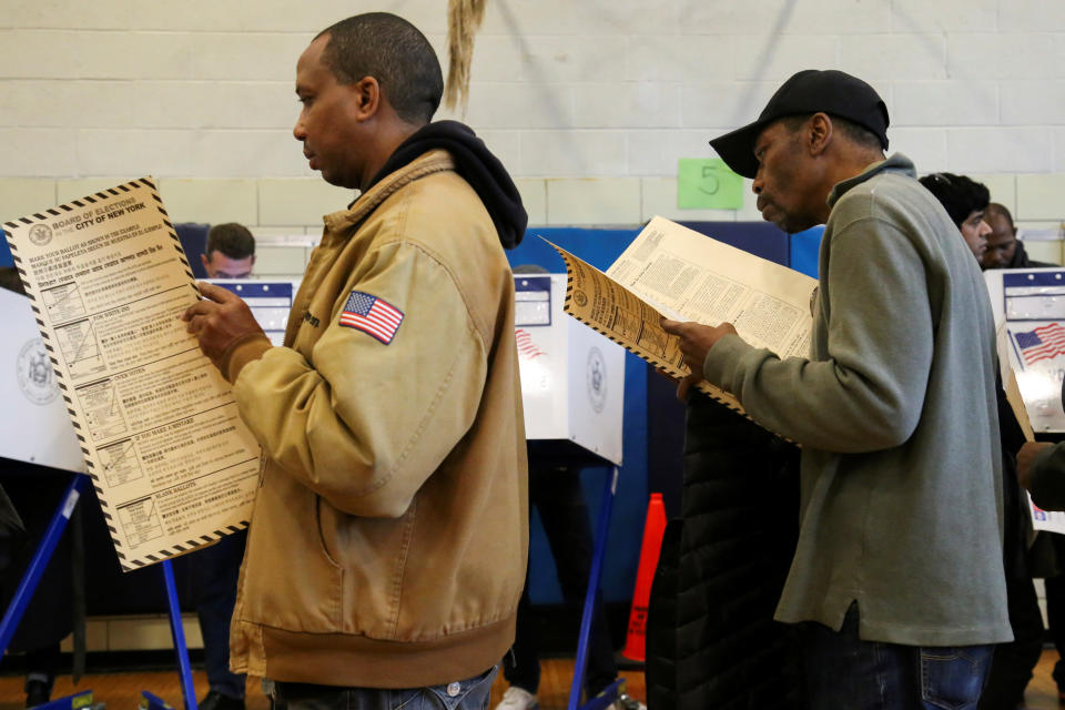 Men read their ballots before casting their vote at a polling station on election day in Harlem, New York, on&nbsp;Nov. 8.&nbsp;