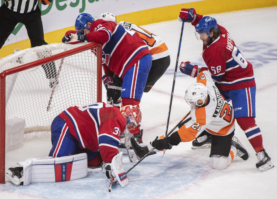 Montreal Canadiens goaltender Cayden Primeau, front left, stops Philadelphia Flyers' Scott Laughton (21) as Canadiens' Mike Hoffman (68) and Jeff Petry (26) defend during overtime NHL hockey game action in Montreal, Thursday, Dec. 16, 2021. (Graham Hughes/The Canadian Press via AP)