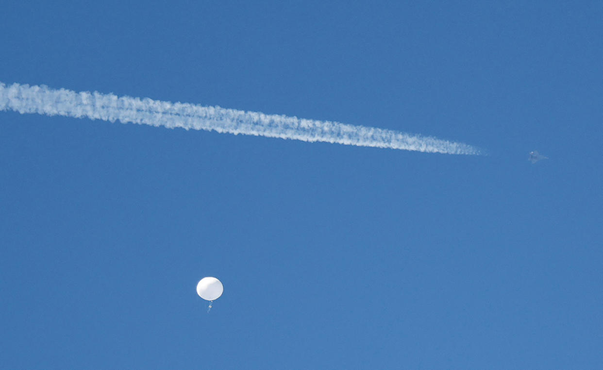 FILE PHOTO: A jet flies by a suspected Chinese spy balloon as it floats off the coast in Surfside Beach