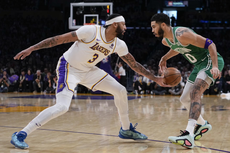 Los Angeles Lakers forward Anthony Davis (3) pokes the ball out of the hands of Boston Celtics forward Jayson Tatum (0) during the first half of an NBA basketball game, Monday, Dec. 25, 2023, in Los Angeles. (AP Photo/Ryan Sun)