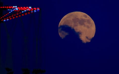 The blood moon rises over Tel Aviv, Israel - Credit: Ariel Schalit/AP