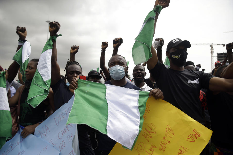 FILE - In this Oct. 19, 2020, file photo, people hold banners as they demonstrate on the street to protest against police brutality in Lagos, Nigeria. The protests started in Lagos against a police unit known as the Special Anti-Robbery Squad, or SARS, which faced widespread accusations of brutality, unwarranted arrests and bribery. It climaxed on Oct. 20, 2020, when protesters were killed nationwide, according to Amnesty International's Nigerian office. (AP Photo/Sunday Alamba, File)