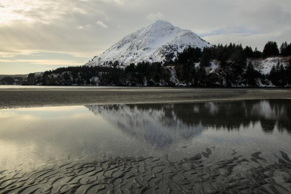 Snowy mountain behind White Sand Beach on Kodiak Island via Getty Images