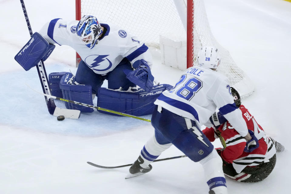 Tampa Bay Lightning goaltender Brian Elliott makes a save on a shot by Chicago Blackhawks' Colin Blackwell, right, as Ian Cole also defends during the second period of an NHL hockey game Tuesday, Jan. 3, 2023, in Chicago. (AP Photo/Charles Rex Arbogast)