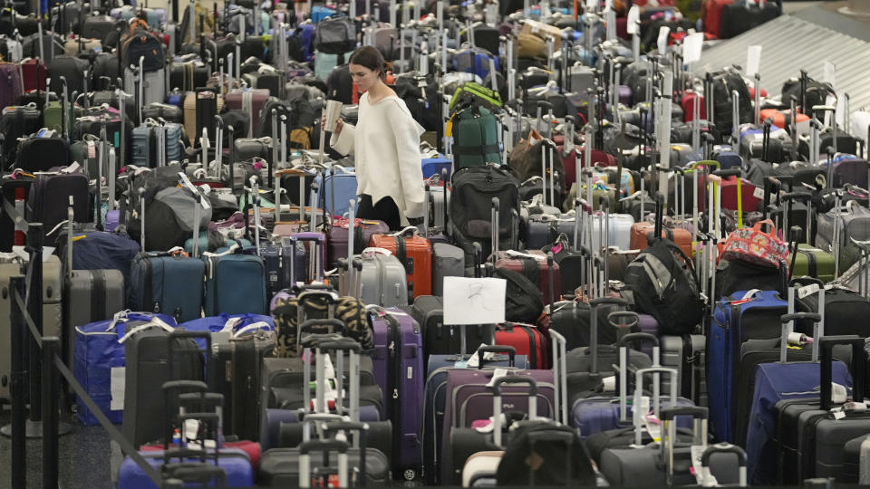 A woman walks through unclaimed bags at Southwest Airlines baggage claim at Salt Lake City International Airport Thursday, Dec. 29, 2022, in Salt Lake City. Southwest Airlines is still trying to extract itself from sustained scheduling chaos and cancelled another 2,350 flights after a winter storm overwhelmed its operations days ago. (AP Photo/Rick Bowmer)