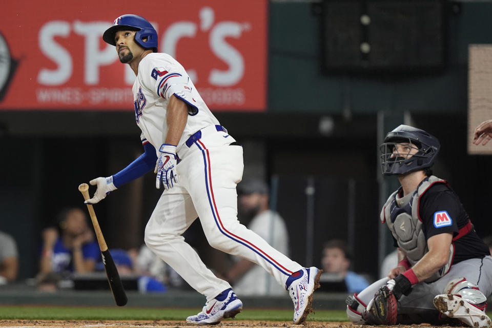 Texas Rangers' Marcus Semien, left, and Cleveland Guardians catcher Austin Hedges watch Semien's home run get away during the fifth inning of a baseball game in Arlington, Texas, Wednesday, May 15, 2024. Rangers Leody Taveras also scored on the play. (AP Photo/LM Otero)