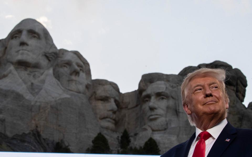 President Donald Trump smiles at Mount Rushmore National Memorial - AP