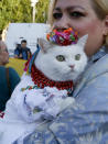 A woman holds her cat as she attends a rally marking Defense of the Homeland Day in center Kyiv, Ukraine, Monday, Oct. 14, 2019. Some 15,000 far-right and nationalist activists protested in the Ukrainian capital, chanting "Glory to Ukraine" and waving yellow and blue flags. President Volodymyr Zelenskiy urged participants to avoid violence and warned of potential “provocations” from those who want to stoke chaos. (AP Photo/Efrem Lukatsky)