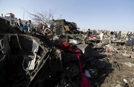 People gather at the site of an air strike at a residential area near Sanaa Airport March 26, 2015. REUTERS/Khaled Abdullah