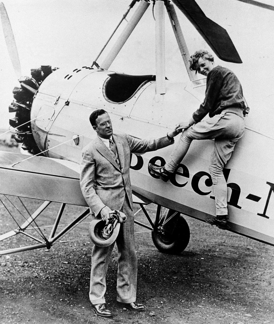American aircraft pilot Amelia Earhart is assisted by her husband, George Palmer Putnam, as she climbs out of the cockpit of her autogiro after completing a transcontinental flight to the West Coast and back, at the Metropolitan Airport in Newark, N.J., on June 22, 1931. (AP Photo)