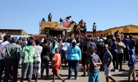 Locals attempt to gain access to a shop before looting during protests in Atteridgeville, a township located to the west of Pretoria, South Africa June 21, 2016. REUTERS/Siphiwe Sibeko