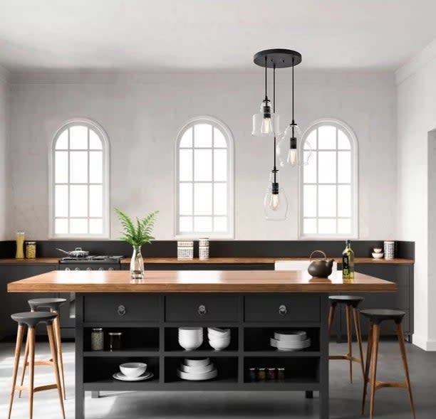 Three-light pendant hanging over a kitchen island