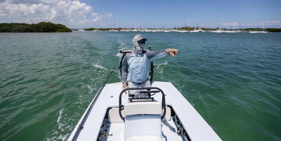 Fishing guide Carl Ball, 58, points while driving his boat near Crandon Park Marina on Saturday, April 22, 2023, in Key Biscayne, Fla. MATIAS J. OCNER/mocner@miamiherald.com