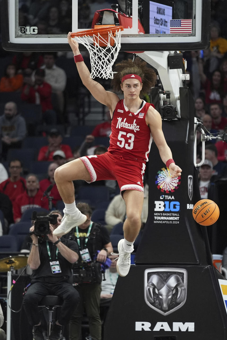 Nebraska forward Josiah Allick (53) hangs on the rim after a dunk during the first half of an NCAA college basketball game against Illinois in the semifinal round of the Big Ten Conference tournament, Saturday, March 16, 2024, in Minneapolis. (AP Photo/Abbie Parr)