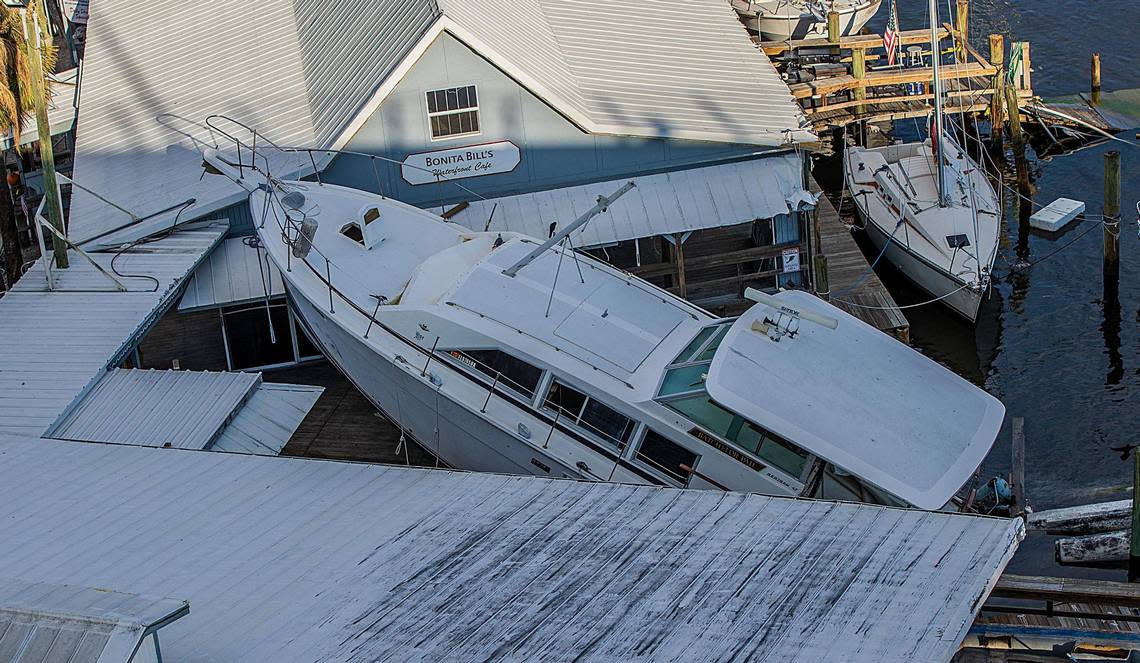 A large boat is half sunk with its bow resting on the dock of Bonita Bill’s Waterfront Cafe, located at Fisherman’s Wharf in Fort Myers Beach, Wednesday, Oct. 26, 2022. The boat was one of hundreds displaced and damaged by Hurricane Ian, which hit the area as a Category 4 storm Wednesday, Sept. 28, 2022.