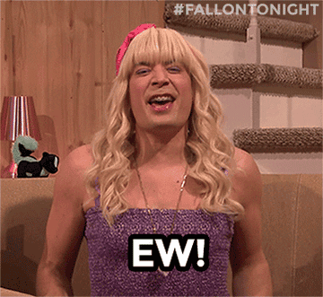 Jimmy Fallon wearing a long, blonde wig and tube top and saying "EW!"