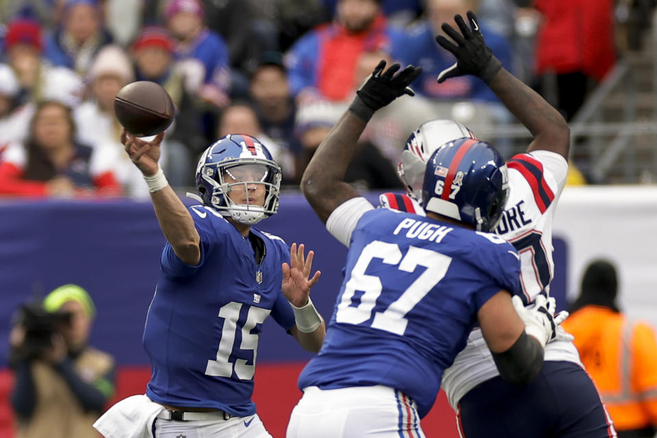 New York Giants quarterback Tommy DeVito (15) passes under pressure against the New England Patriots during the first quarter of an NFL football game, Sunday, Nov. 26, 2023, in East Rutherford, N.J. (AP Photo/Adam Hunger)