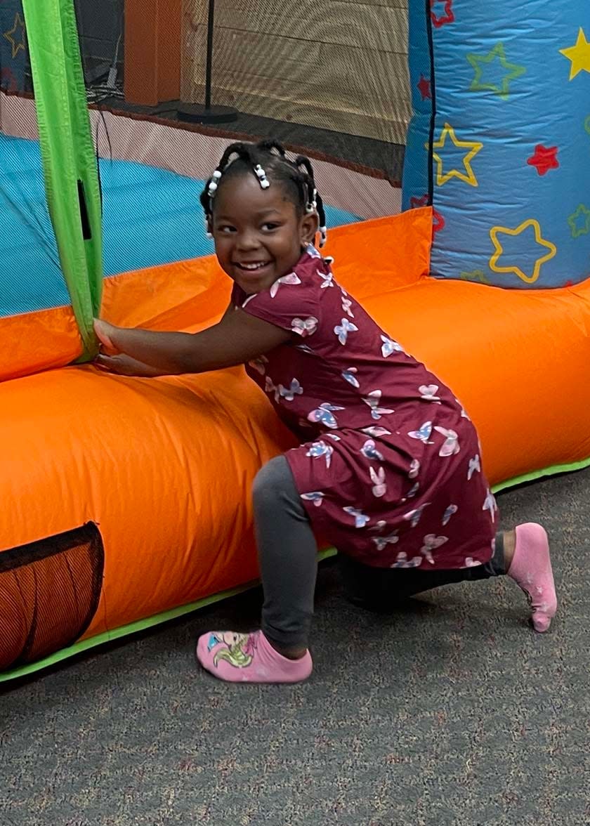 Amanda Eversley, 4, looks like she’s up to mischief but she’s actually about to take a dive into an inflatable castle at the Easter Eggstravaganza at West Towne Christian Church, April 2, 2023.