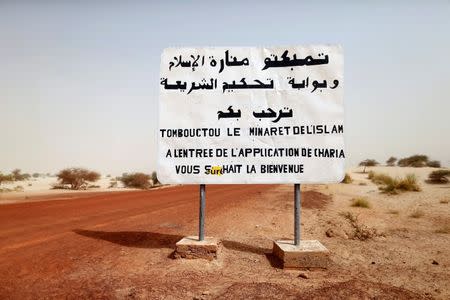 A road sign written by Islamist rebels is seen at the entrance into Timbuktu January 31, 2013. The sign reads, "Timbuktu, the minaret of Islam and the entrance to the application of the Sharia law welcomes you." REUTERS/Benoit Tessier/Fles