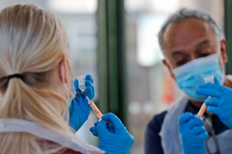 <p>Doctor Anil Mehta and Apprentice Nursing Associate Ellie Bull prepare syringes with doses of the AstraZeneca vaccine</p> (AP)