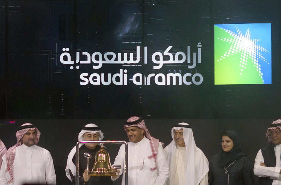 Saudi Arabia's state-owned oil company Armco and stock market officials celebrate during the official ceremony marking the debut of Aramco's initial public offering (IPO) on the Riyadh's stock market, in Riyadh, Saudi Arabia, Wednesday, Dec. 11, 2019. (AP Photo/Amr Nabil)