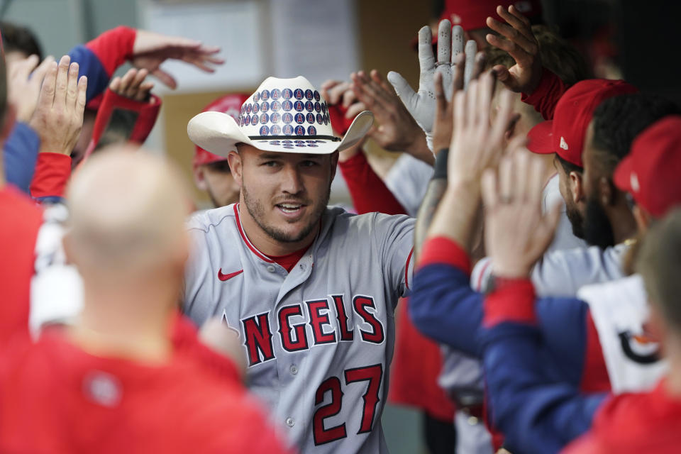 Los Angeles Angels' Mike Trout wears a cowboy hat as he is greeted in the dugout after he hit a two-run home run during the third inning of the team's baseball game against the Seattle Mariners, Thursday, June 16, 2022, in Seattle. (AP Photo/Ted S. Warren)