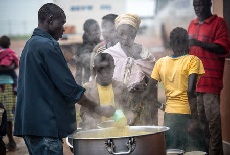 South Sudanese people receive a hot meal at a transit centre in Koluba before boarding courtesy buses to Imvepi refugee settlement camp in Arua District, northern Uganda August 12, 2017. REUTERS/Jason Patinkin