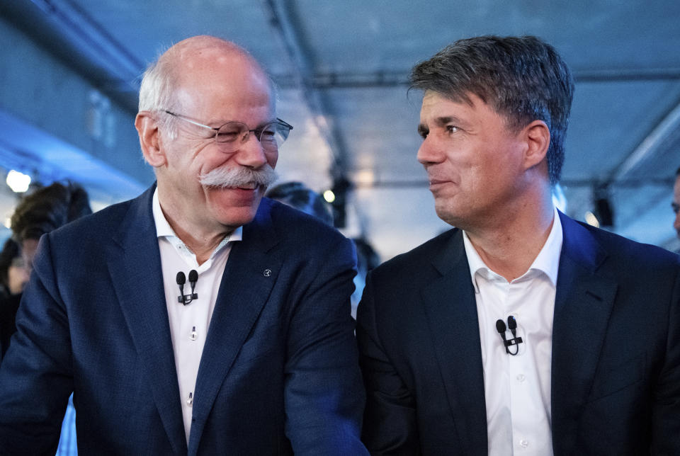 BMW CEO Harald Krueger, right, and Mercedes-Benz CEO Dieter Zetsche of Daimler, left, sit together at a press conference in Berlin, Germany, Friday, Feb. 22, 2019. Automakers Daimler and BMW are formally launching their joint venture in services that make it possible to use their cars without necessarily owning one. (Bernd von Jutrczenka/dpa via AP)