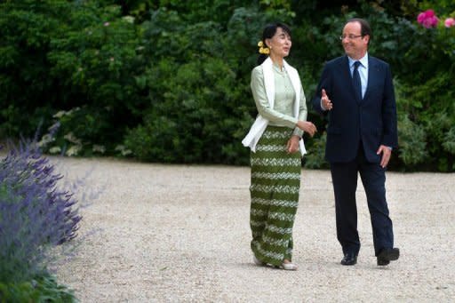 France's President Francois Hollande and Myanmar pro-democracy leader Aung San Suu Kyi walk in the garden of the Elysee presidential palace following a meeting, in Paris. Hollande told Suu Kyi Tuesday that France would do everything possible to back the country's democratic transition, as she visited Paris for the last leg of a landmark European tour