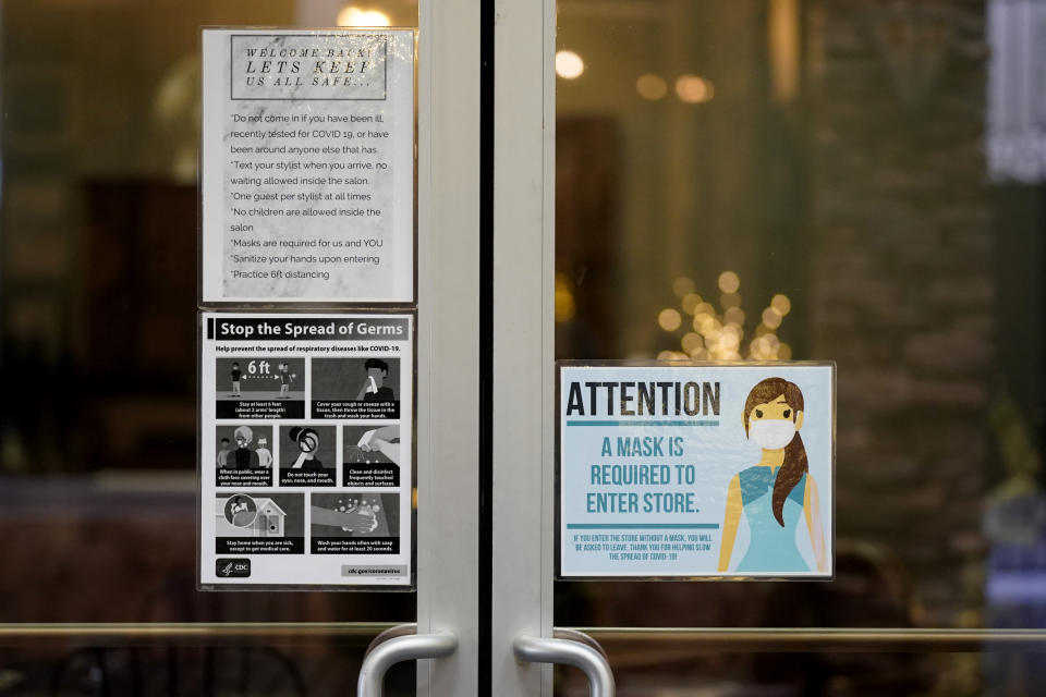 Signs posted on the door of the Luscious Salon advises customers about the pandemic guidelines followed, Lodi, Calif., Wednesday, Dec. 9, 2020. Lodi, a city of just under 68,000 people, is part of the San Joaquin Valley region. The coronavirus is spreading rapidly in California's San Joaquin Valley and filling its hospitals. It has the fewest available intensive care unit beds of any region in California, a frightening reality that health officials hope will convince more people to wear masks and socially distance. (AP Photo/Rich Pedroncelli)
