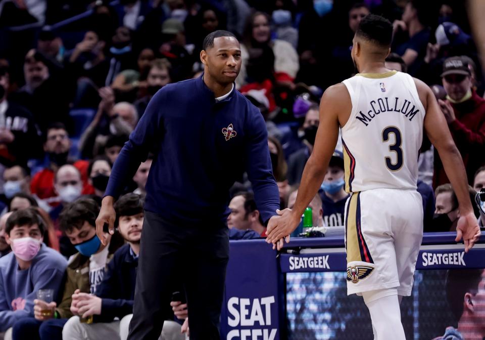 New Orleans Pelicans head coach Willie Green (left) talks with New Orleans Pelicans guard CJ McCollum (3) who exits an NBA basketball game in the second half against the Miami Heat in New Orleans on Feb. 10, 2022.