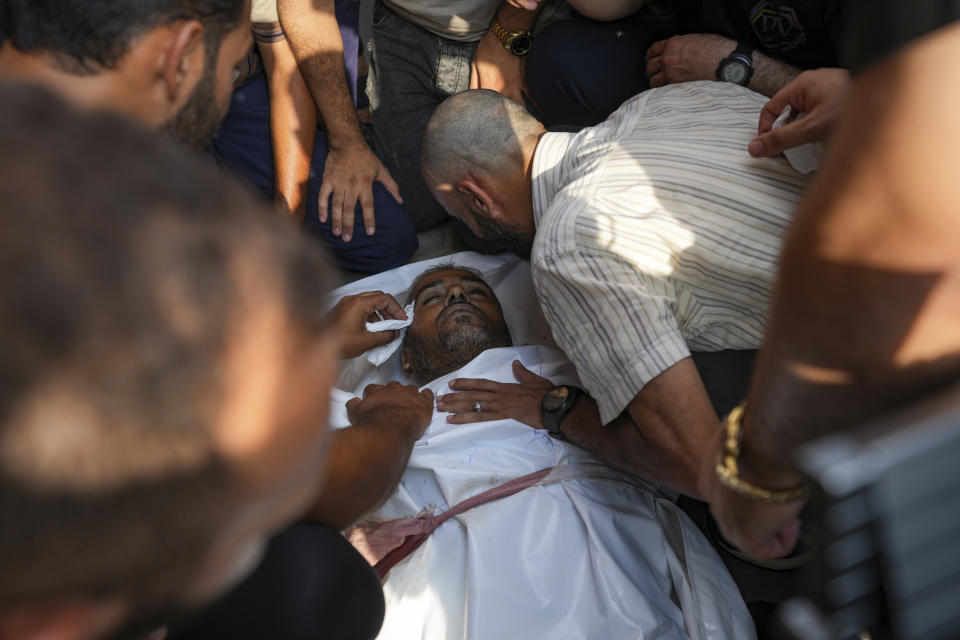 Palestinians mourn one of the three civil defense members killed in the Israeli bombardment of Nuseirat refugee camp, at al-Aqsa Martyrs Hospital in Deir al Balah, central Gaza Strip, Friday, June 28, 2024. (AP Photo/Abdel Kareem Hana)