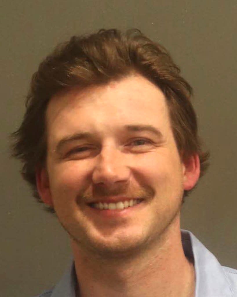 Morgan Wallen grinning in his mug shot. AP