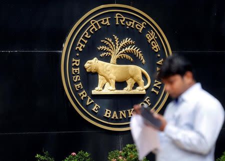 FILE PHOTO: A man checks his phone outside the Reserve Bank of India (RBI) headquarters in Mumbai, India June 7, 2017. REUTERS/Shailesh Andrade/File Photo