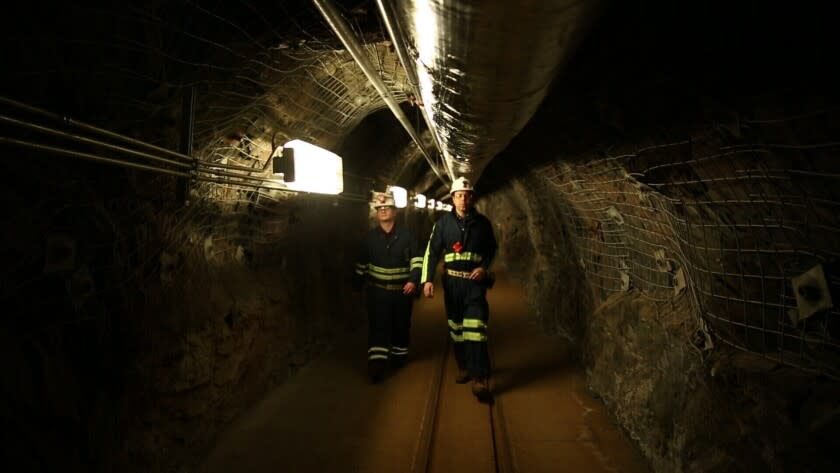 Dos científicos caminan por un túnel de una vieja mina de oro, a un kilómetro y medio (una milla) de profundidad, en Lead (Dakota del Sur), donde funciona un centro de investigaciones que trata de encontrar materia oscura en las profunidades de la Tierra. Foto del 8 de diciembre del 2019. La materia oscura constituye la mayor parte de la masa del universo, pero nunca ha sido vista. (AP Photo/Stephen Groves)