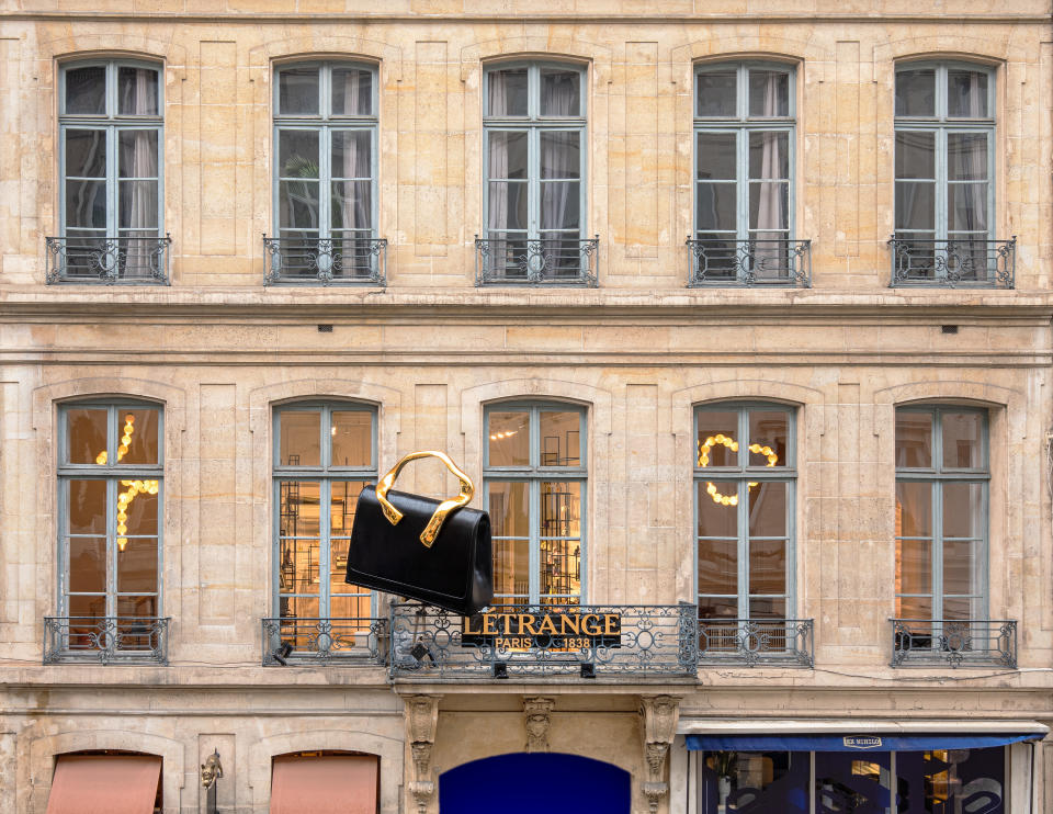 A giant handbag hangs from the balcony of 352 Rue Saint-Honoré.